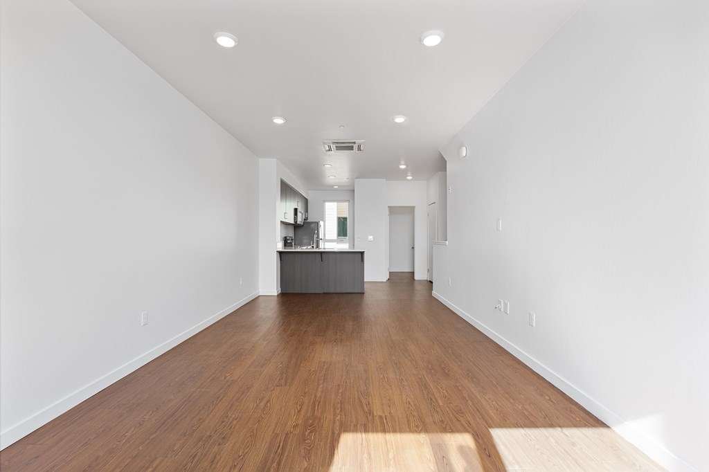 A long hallway with a kitchen area at the end.